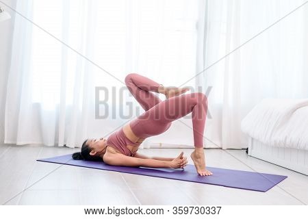 Young Woman Do Yoga In A Bed Room