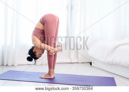 Young Woman Do Yoga In A Bed Room