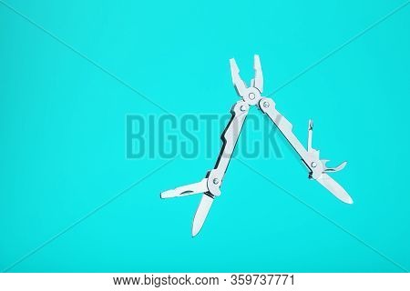 The Multitool Multi-function Tool Hovers On A Blue Background. The Concept Of An Expanded Multi-tool