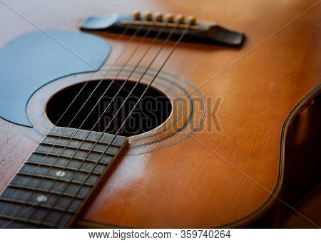 Acoustic Guitar. Top View For Part Of Neck And Body With Wooden Top, Sound Hole, Strings And Bridge 
