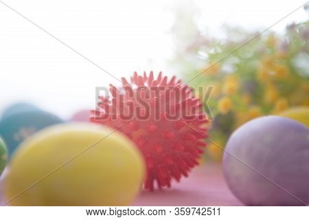 Virus Model Of Coronavirus Disease Covid-19 With Colorful Easter Eggs On A Pink Wooden Table Backgro