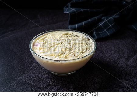 Profiteroles With White Chocolate In Glass Bowl.