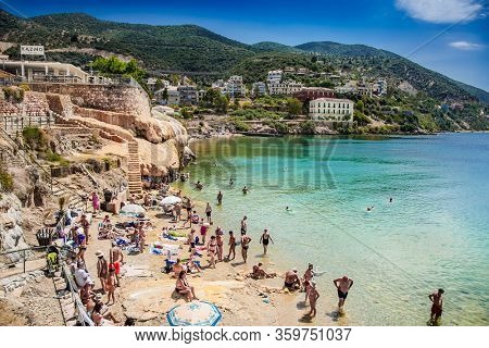 Loutra Edipsou, Evia, Greece- June,11 2018. Enjoying tourists in the warm medicinal spa water that springs from the rocks on the Aegean coast. Lutra Edipsou, Evia island, Greece