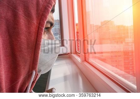 Young Man In A Protective Mask At Home. Isolated To Prevent Infection Of Coronavirus, Covid-19 Epide