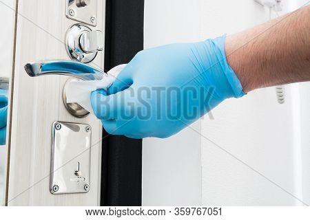 Man Hand In Blue Gloves Cleaning Door Knob With Disposable Napkin. Coronavirus Quarantine Time. Miso