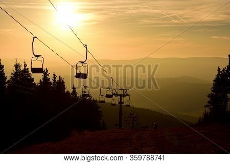 Ski Chair Lift Cable Car In The Mountains At Orange Sunrise