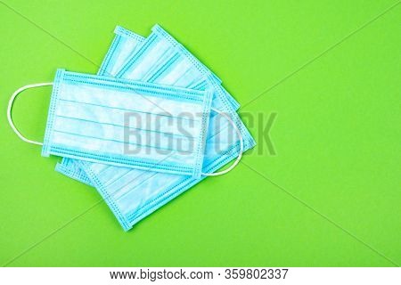 Top View Of Disposable Medical Surgical Protective Face Mask On Greenbackground. Mask Against Virus,