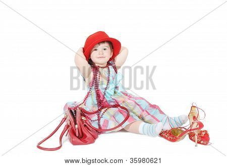 小女孩尝试对妈妈的帽子和珠