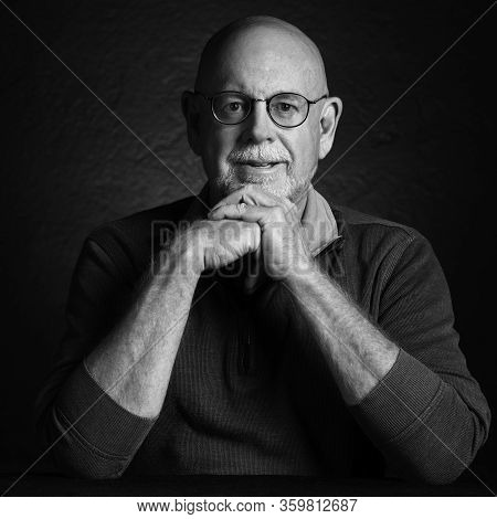 Artistic Studio Portrait Headshop Of A Cheeerful Senior In Black And White.