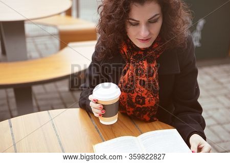 A Pretty Woman Was Distracted From Reading An Interesting Book On The Terrace Of A Street Restaurant