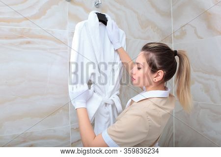 A Terry-cloth Robe In The Hands Of A Maid. The Concept Of The Hotel Business. Copy Of The Space