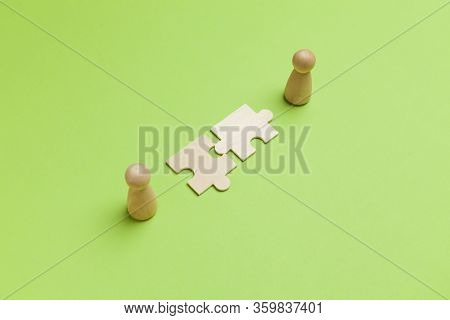 Wooden Figures With Pazzles On Green Background. Agreement Between Business Mans, Cooperation And De