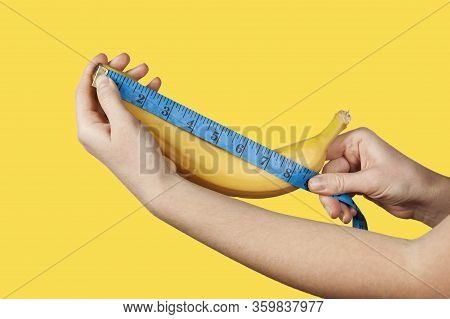 Measuring The Size Of A Banana As A Symbol Of The Male Penis On Yellow Background. Big Dick Length. 