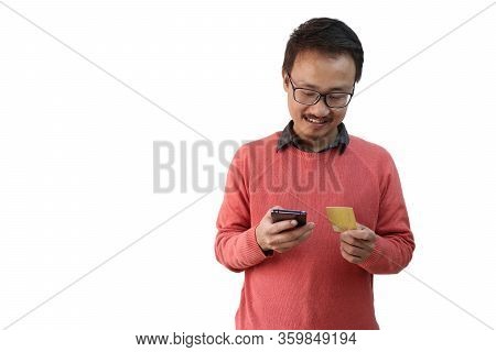 A Man Looking At His Credit Card And Smartphone. E Commerce And Payment Concpt Image Isolated In Whi