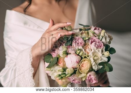 The Bride Holds In Her Hands A Bridal Bouquet Of The Bride In Pink Style, The Bouquet Is Tied With A