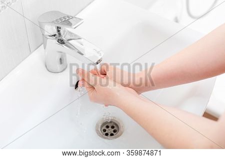 Washing Femle Hands In A Ceramic Washbasin With A Chrome-plated Faucet Under The Pressure Of Water, 