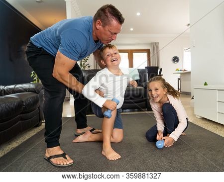 Family Exercising Together During Covid-19 Lockdown. Father And Children In Isolation Having Good Ti