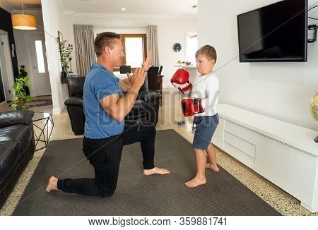 Covid-19 Shutdown. Father And Son Having Fun Boxing Together And Staying Physically Active At Home D