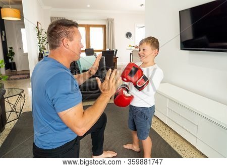 Covid-19 Shutdown. Father And Son Having Fun Boxing Together And Staying Physically Active At Home D