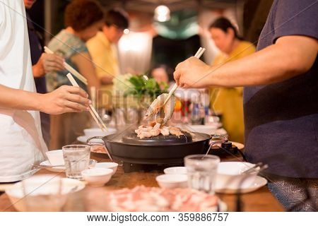 Family Dinner Hand With Chopstick Cooking Praw On Hot Bbq Pan
