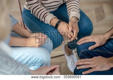 Group Of People Sitting In A Circle Close To Each Other