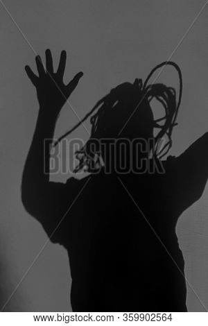 Scary Silhouette Of Crying Person, Terrifying Shadow On Dark Wall Or Behind Mirror. Horror, Nightmar