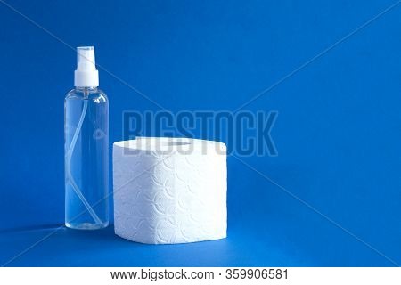Bottle Of Anitizer And White Toilet Paper On The Blue Background
