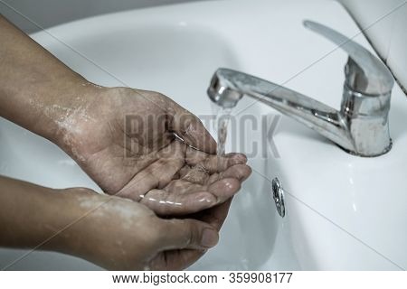 Woman Washing Hands Under The Water Tap In Bathroom With Using Soap Gel For Cleaning And Prevention 
