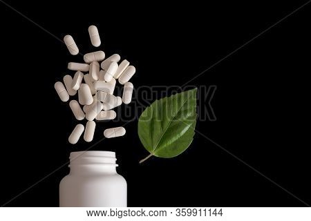 A White Jar With Pills, A Beautiful Pile Of Them, And A Green Leaf. Healthy Lifestyle, Homeopathy. T