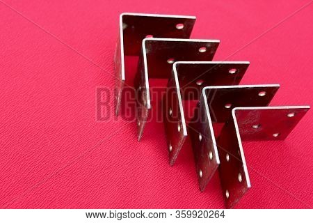Arrow Made Of Brackets Isolated On Pink. Metal Corners Are Directed To The Up With A Place For The T