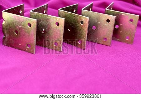 Arrow Made Of Brackets Isolated On Pink. Metal Corners Are Directed To The Left With A Place For The