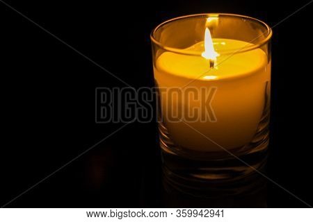 Candle In A Glass Jar On A Dark Background