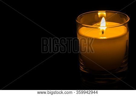 Candle In A Glass Jar On A Dark Background