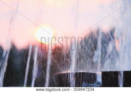 Water Jet Fountain On Sunset Background And Red Sunset
