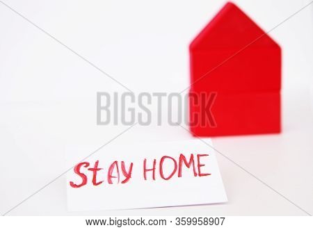 Toy House On A White Background. A Toy House Made Of Red Cubes. With A Red Sign Saying Stay At Home.