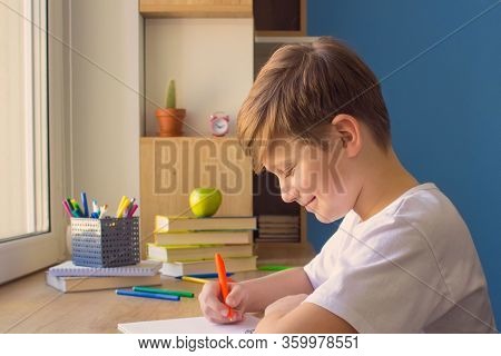 Happy Child Boy Wirting In His Copybook, Doing Homework At Home