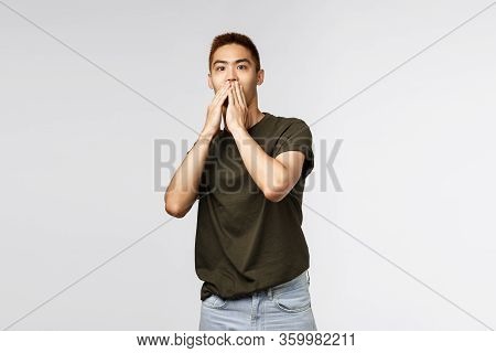 Portrait Of Shocked, Speechless Asian Guy Gasping, Cover Mouth And Express Shook And Surprised With 