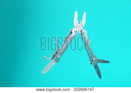 The Multitool Multi-function Tool Hovers On A Blue Background. The Concept Of An Expanded Multi-tool