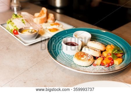 Chef Preparing Healthy Food In Kitchen In The Restaurant. Breakfast. Fried Eggs, Salad With Meat And