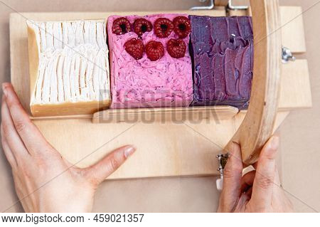 A Soap Maker Cuts Multi-colored Pieces Of Soap On A Special Wooden Device. View From Above. Only Han