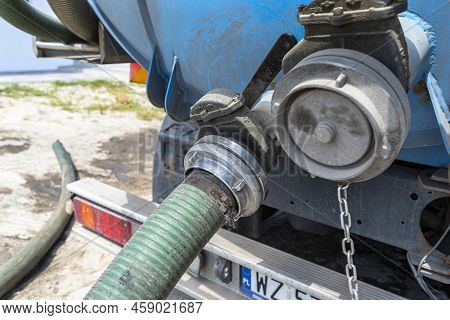 Long 4 Inch Pvc Suction Hose Connected To The Flange Fitting On The Trucks Tank.
