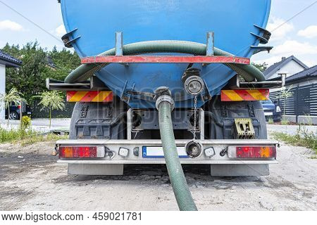 Long 4 Inch Pvc Suction Hose Connected To The Flange Fitting On The Trucks Tank.