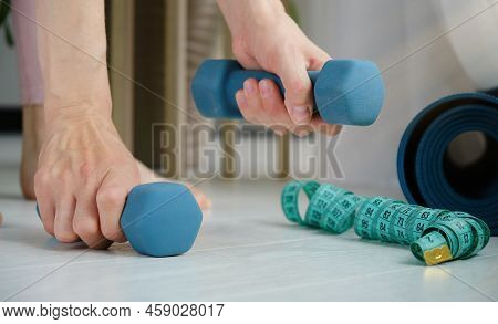 Portive Woman Doing Squats While Holding Dumbbells With Straight Hands.