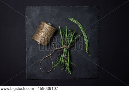 String Beans On A Black Background. A Bunch Of Raw Green Beans Tied With A Rope. Healthy Vegetable