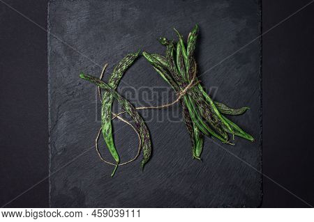 String Beans On A Black Background. A Bunch Of Raw Green Beans Tied With A Rope. Healthy Vegetable