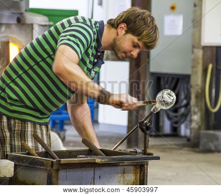Arbeiter produzieren ein Stück Glas