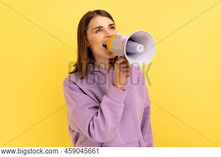 Portrait Of Beautiful Woman Screaming Loudly In Megaphone, Announcing Important Advertisement, Prote