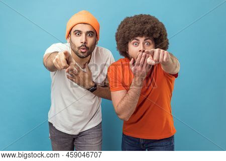 Wow, Look At This. Portrait Of Two Astonished Surprised Young Adult Hipster Men Looking At Camera Wi