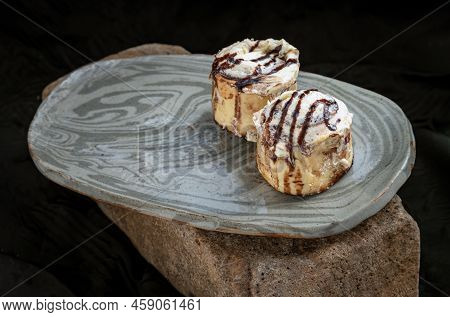 Two Cinnabon Chocobon (soft Chocolate Buns) Topped With Rich Cream Cheese Frosting On Ceramic Tray W