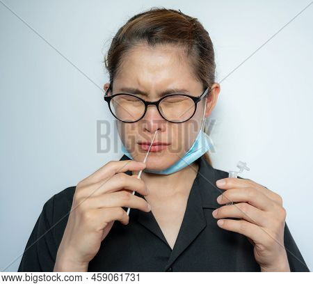 Asian Woman Using Rapid Antigen Test Kit By Nasal Swab Herself For Takes A Sample Of Cells From The 